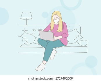 Woman in mask working on a laptop from home. Covid-19