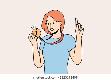 Woman with medal for first place won sports competition and is proud of trophy pointing finger up. Girl champion boasts of award for winning olympiad or participants in competition among colleagues