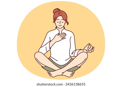 Woman meditates with hand on heart and wishes to heal herself through yoga and Buddhist spiritual practices. Girl sitting in lotus position takes care of heart chakra and relaxes during yoga