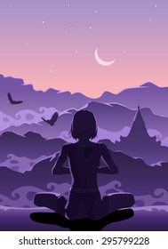Woman meditating in the mountains early in the morning