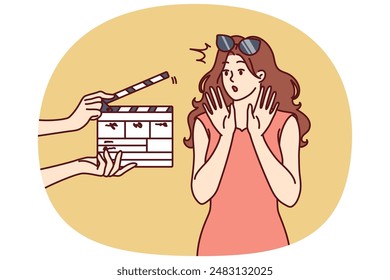 La estrella de cine mujer se avergüenza de ver clapboard pasando el casting para el papel en series populares o programas de televisión. Chica estrella de cine saludando con las manos, sin querer filmar o responder preguntas de los reporteros