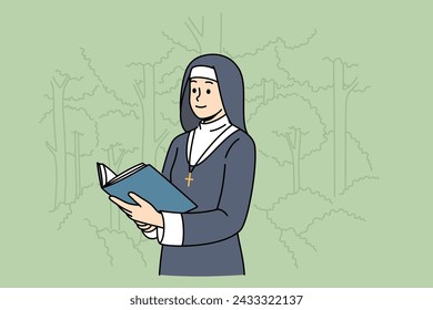 Woman nun with holy book stands in park among trees, dressed in cassock for religious service in temple. Nun studies sacred scriptures and prayers during breaks between prayer services in cathedral