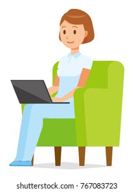 A woman nurse wearing a white uniform is sitting on the sofa and operating a laptop computer