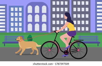 Woman on a bike for a walk with a dog in a city park. The concept of a healthy lifestyle together with pets