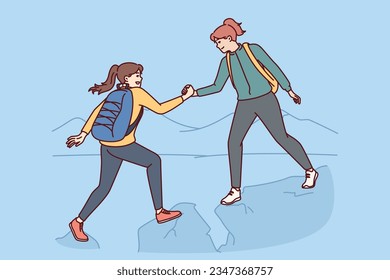 Woman on hike helps female friends by climbing peak of high cliff and shaking new apex. Hiking trip of two young girls with backpacks traveling through dangerous high mountain areas