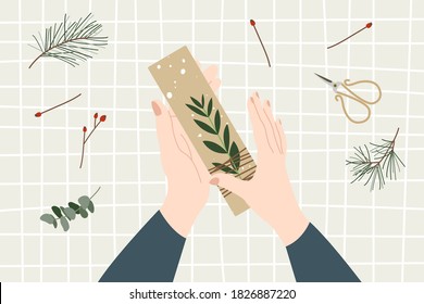 Woman packing a christmas gift, holiday workshop. Eco decoration, flat lay. Presents in kraft paper. Rustic gift box. Xmas and New Year celebration preparation. Vector flat cartoon style