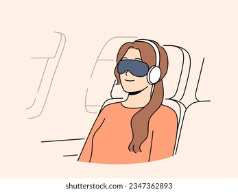 Una pasajera de vuelo con venda en los ojos y audífonos duerme en una silla de avión sentada fuera del ojo de buey. Niña joven pasajera de primera clase vuela en viaje de negocios en avión y sonrisas