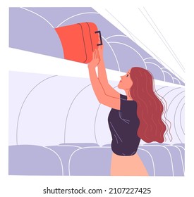 Woman passenger puts her hand baggage on the overhead shelf.