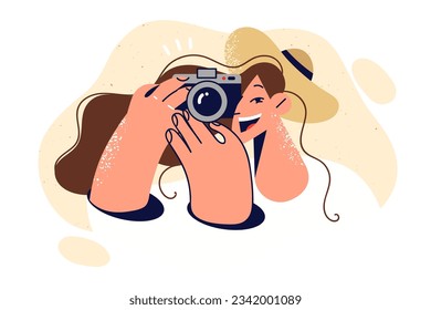 Woman photographer with smile takes picture on camera to capture happy moments from life. Young pretty girl photographer making snapshots for online portfolio or personal photo album