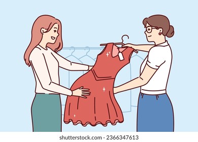 Woman picks up dry-cleaner dress standing in laundry room next to employee demonstrating cleaned clothes. Happy girl visitor to boutique, buys red evening dress for going to party.