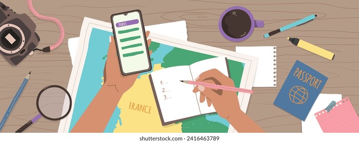 Woman planning her trip to France. Enroute France. Taking notes to notebook on map background. Finding a route on your smartphone.