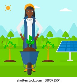 Woman with plant and wheelbarrow.