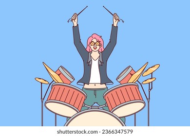 Woman plays drums, performing in front of audience at rock concert or theme party in nightclub. Young superstar girl with pink hair performs incendiary music on drums during festival