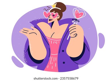 Woman princess in heart-shaped glasses holds lollipop, dressed in image of fairy from fantastic story or children cartoon. Girl with crown on head looks extravagant and dreams of becoming princess