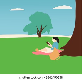Woman with protective mask reading a book under a tree in a nature park. coronavirus concept.