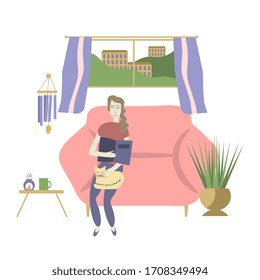 Woman reading book at home with cat on her knees