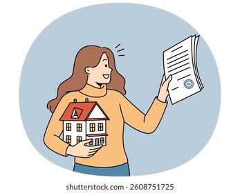 Woman realtor helps people in purchasing real estate and holds mortgage contract and model of house in hand. Realtor girl smiles, rejoicing at selling house and receiving percentage for work.