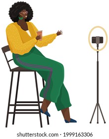Woman is recording video on smartphone. African american girl is broadcasting live, podcasting using phone. Record video, live online podcast. Female blogger broadcasting, recording video blog
