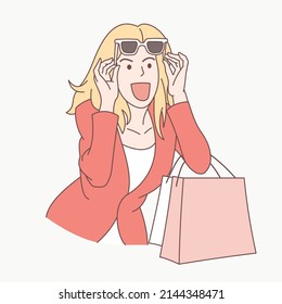 Woman in a red suit holding a shopping bag, looks awake at what she sees until she has to take off her glasses isolated on white background