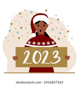 A woman in a red sweater and with a cap holds a sign or poster with the numbers 2023. Postcard or greeting Merry Christmas and Happy New Year.