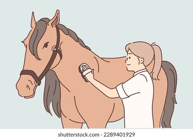 Woman rider takes care of thoroughbred horse by combing animal mane before important races. Girl rider strokes thoroughbred horse using comb for grooming and is fond of breeding equine