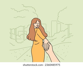 Woman says follow me and takes boyfriend to park for friendly or romantic date in summer nature. Happy girl holding friend hand and turning around, posing for photo in follow me style