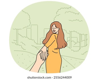 Woman says follow me and takes boyfriend to park for friendly or romantic date in summer nature. Happy girl holding friend hand and turning around, posing for photo in follow me style