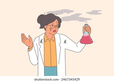 Woman scientist experienced failure when mixing reagents, holds smoking test tube in hands. Failure in laboratory research caused explosion in girl scientist standing in white shabby coat