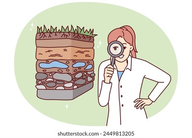 Woman scientist with magnifying glass is engaged in geology in search of deposits of valuable resources. Girl ecologist in white coat conducts examination of soil pollution