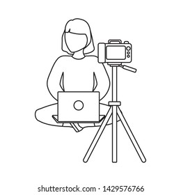 woman seated using laptop computer with photographic camera