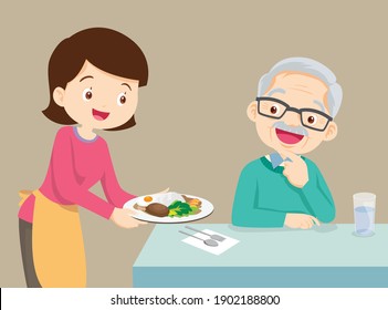 Woman serving food to elderly man, Lovely daughter serving food to father, family enjoy cooking.