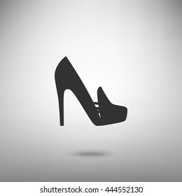 Woman shoes sign. Dark gray icon with shadow on floor.