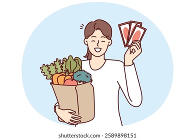 Woman shopper holding gift vouchers from supermarket and paper bag filled with fresh vegetables. Happy girl showing off discount coupons or vouchers for shopping at grocery store at bargain prices