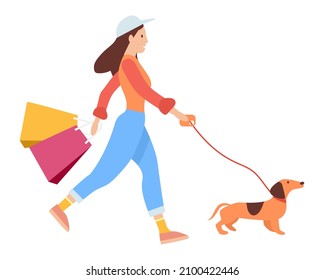 Woman with shopping bags in her hands goes after purchases. Young beautiful fashion shopper girl isolated on white background. Sale advertising. Female character is walking with the dog on the street