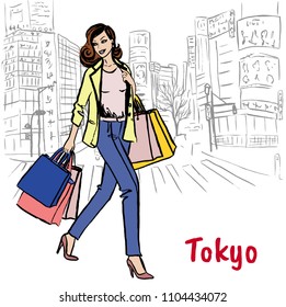 Woman with shopping bags walking on street in Shibuya, Tokyo, Japan