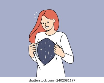 Woman shows depth of soul and inner world with smile, showing stars under shirt. Concept of caring for your own soul and inner harmony achieved through meditation or getting rid of stress