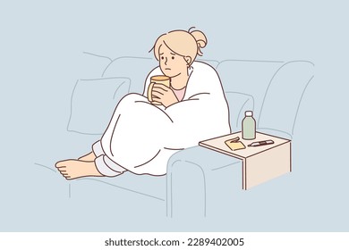 Woman sick with flu wrapped in blanket sits on couch and drinks hot decoction of herbs to get rid of infection. Unhappy girl is suffering from flu outbreak and is waiting for doctor to arrive.