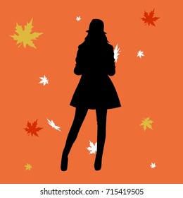 woman silhouette in leaves in the autumn