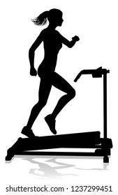 A woman in silhouette using a treadmill running machine piece of gym fitness equipment 