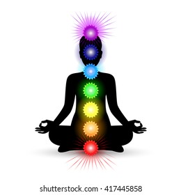 Woman silhouette in yoga pose with shining chakras