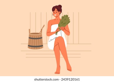 Woman sits in bathhouse and smiles, enjoying thermal treatments that improve well-being and get rid of toxins. Girl visitor to bathhouse holds birch broom located near wooden bucket