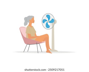 A woman sits in a chair with a fan blowing on her. The woman is enjoying the cool breeze from the fan.Concept Menopause woman