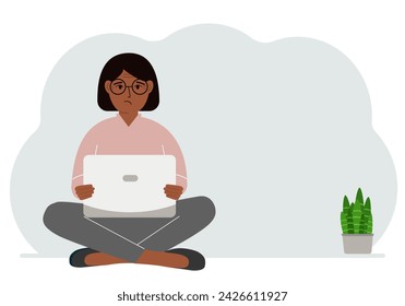 A woman sits cross-legged in his hands holding a laptop. The concept of work, education, reading, watching videos.
