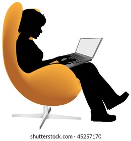 A woman sits in an egg chair to work or shop on a laptop computer.