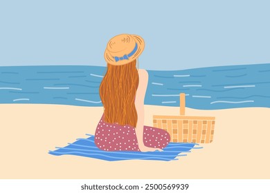 A woman sits on a beach, gazing at the ocean. She wears a sunhat and polka dot dress, with a picnic basket beside her on a blue blanket. Peaceful scene