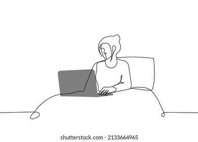 woman is sitting in bed in pajamas with an open laptop on her knees - one line drawing. work from home concept, freelancer at work, business correspondence, morning or before bed 