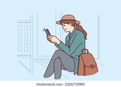 Woman is sitting at bus stop using phone to track public transport via GPS navigation. Successful girl tourist waiting for bus or tram after arriving in new city for business trip.