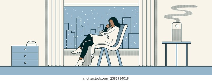 Woman sitting in a chair in snowy weather. A woman wrapped in a blanket and sitting at home in front of the window. Snow and winter. Air humidifier in the interior. Character is resting and relaxing. 