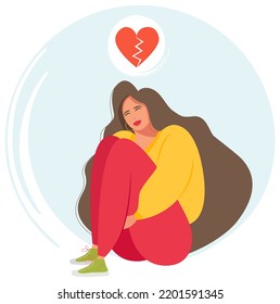 A woman sitting cross-legged, depressed after a breakup, with a broken heart over her head. Broken love. The girl is crying, sad.