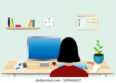 The woman is sitting at a desk in the office and has an empty PC monitor in front of her
